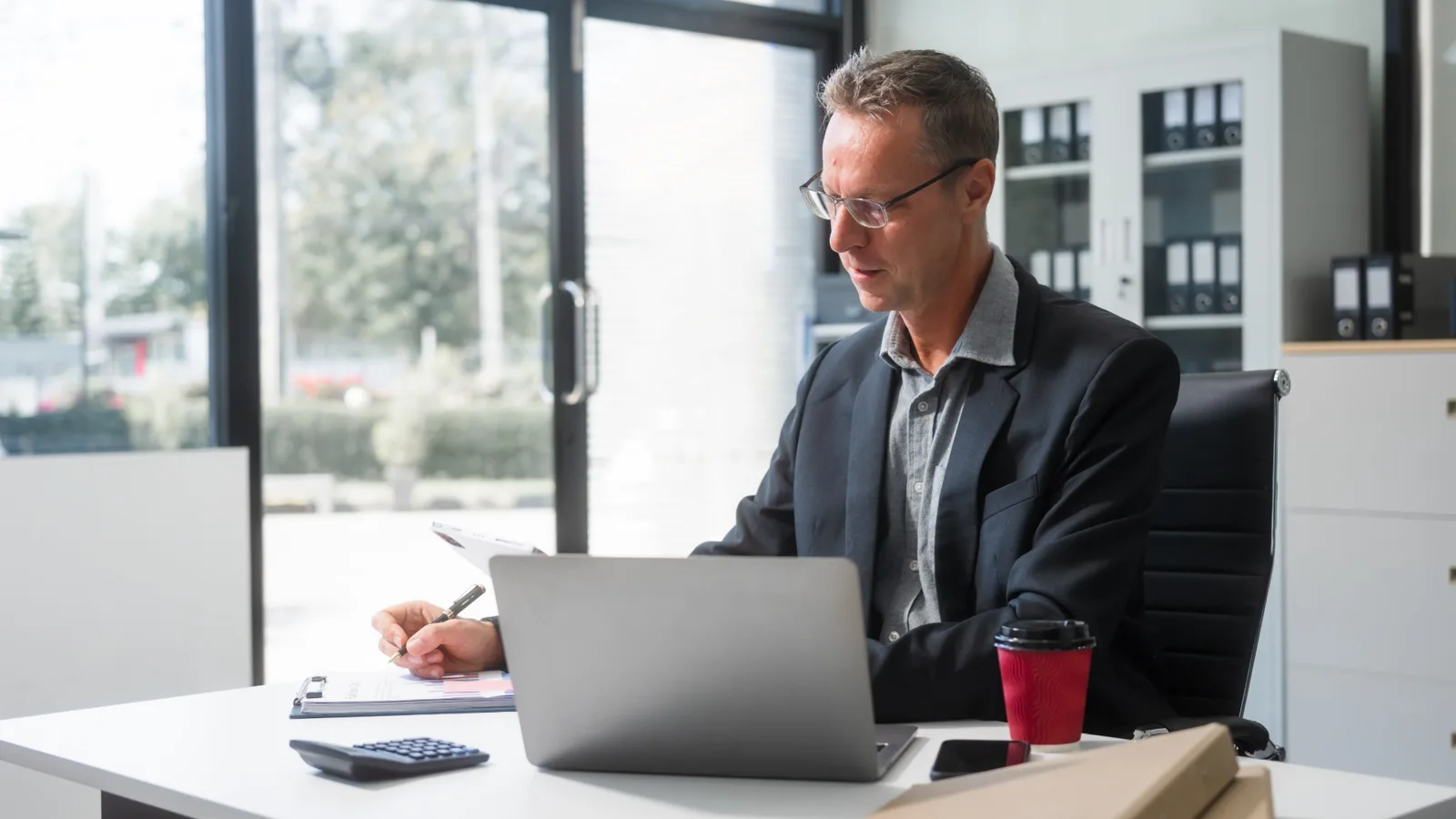 A professional considering documents at an office desk