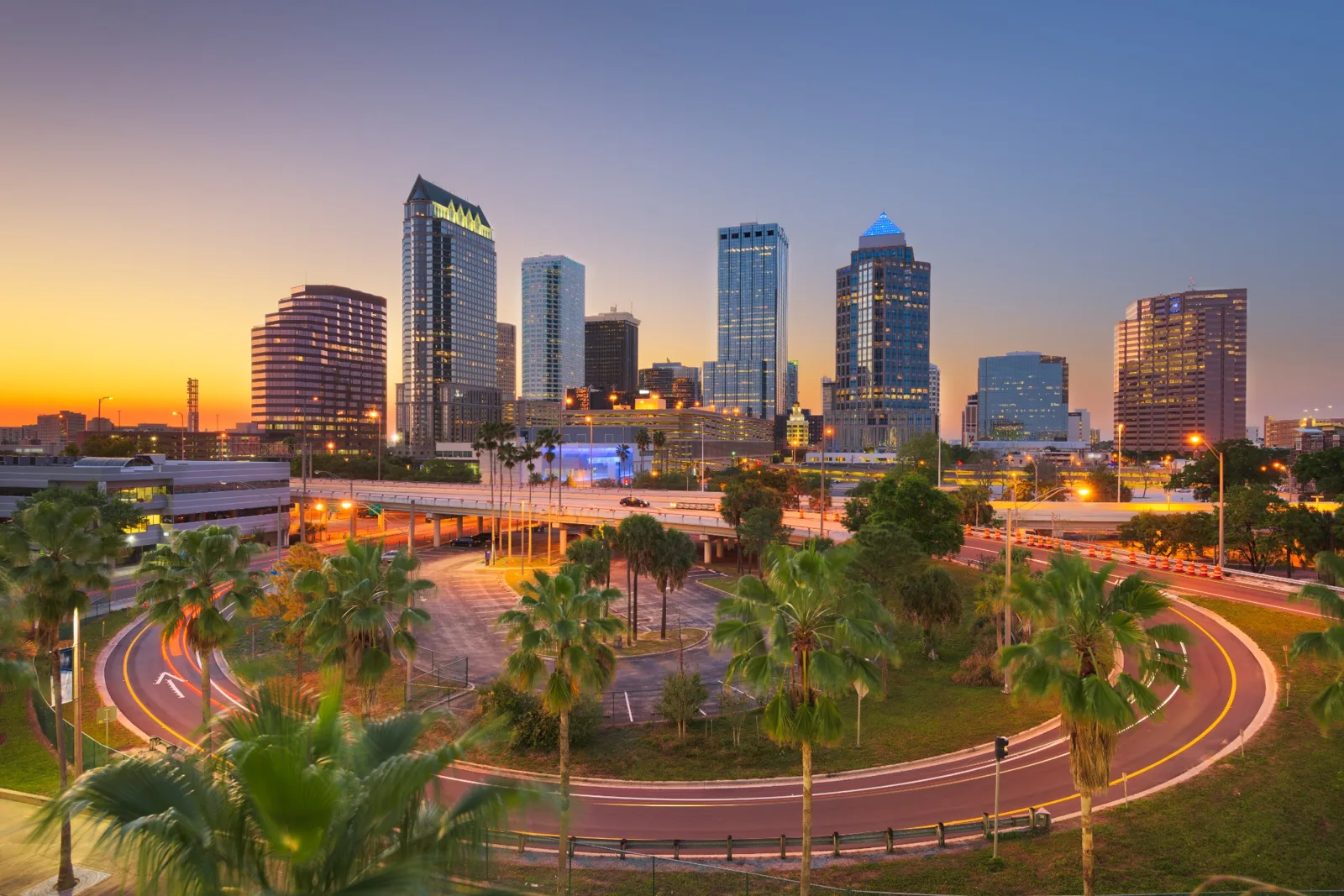 Tampa skyline at sunset above a palm lined waterfront park